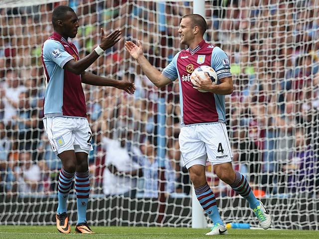 Villa's Ron Vlaar is congratulated by team mate Christian Benteke after scoring his team's second goal against Malaga during a friendly match on August 10, 2013