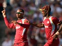 West Indies cricketer Marlon Samuels and team captain Darren Sammy celebrate dismissing England's batsman Eoin Morgan during the first T20 match between England and West Indies at the Kensington Oval in Bridgetown on March 9, 2014