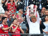 Arsene Wenger manager of Arsenal lifts the trophy in celebration alongside Lukas Podolski, Mikel Arteta and Thomas Vermaelen after the FA Cup with Budweiser Final match between Arsenal and Hull City at Wembley Stadium on May 17, 2014