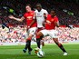 Christian Benteke of Aston Villa battles for the ball with Luis Antonio Valencia and Phil Jones of Manchester United during the Barclays Premier League match between Manchester United and Aston Villa at Old Trafford on April 4, 2015