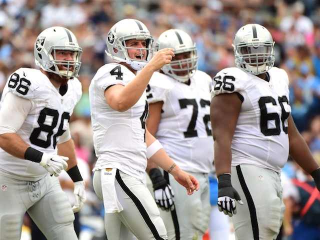 Derek Carr #4 of the Oakland Raiders calls to the bench in front of Lee Smith #86, Donald Penn #72 and Gabe Jackson #66 during the game against the San Diego Chargers at Qualcomm Stadium on October 25, 2015 in San Diego, California.
