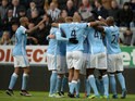 Manchester City players huddle around Sergio Aguero to celebrate the opening goal in their Premier League clash with Newcastle United on April 19, 2016
