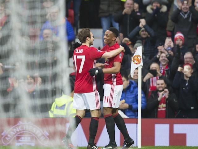 Anthony Martial celebrates with Daley Blind as a net curtain blows into view during the FA Cup game between Manchester United and Reading on January 7, 2017